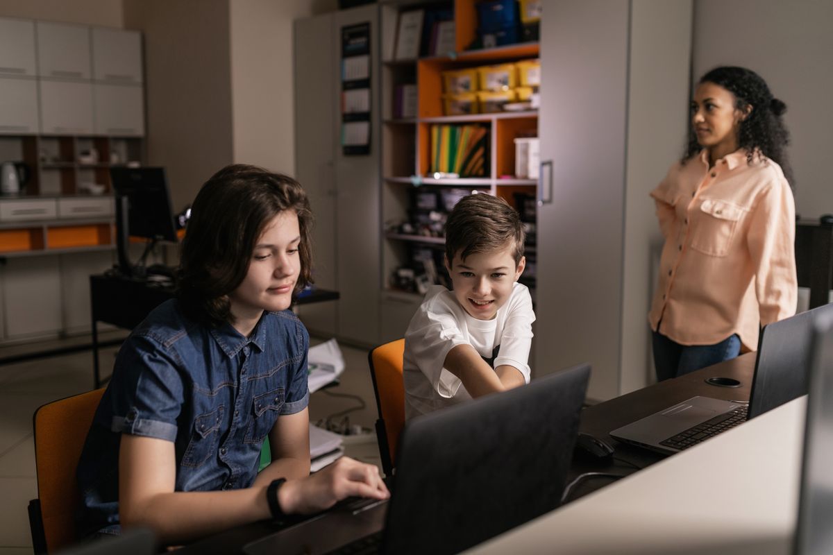 Students working together on laptops in a classroom, an illustrative stock photograph